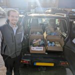 Jimmy posing infront of a car boot full of food