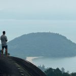 Liam standing on a hill overlooking a misty vista in southeast Asia