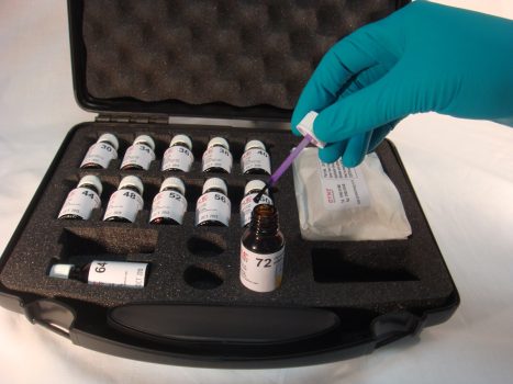 Carrying case containing an array of Dyne test inks in bottles