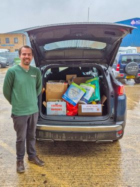 James standing next to a car boot full of food bank donations